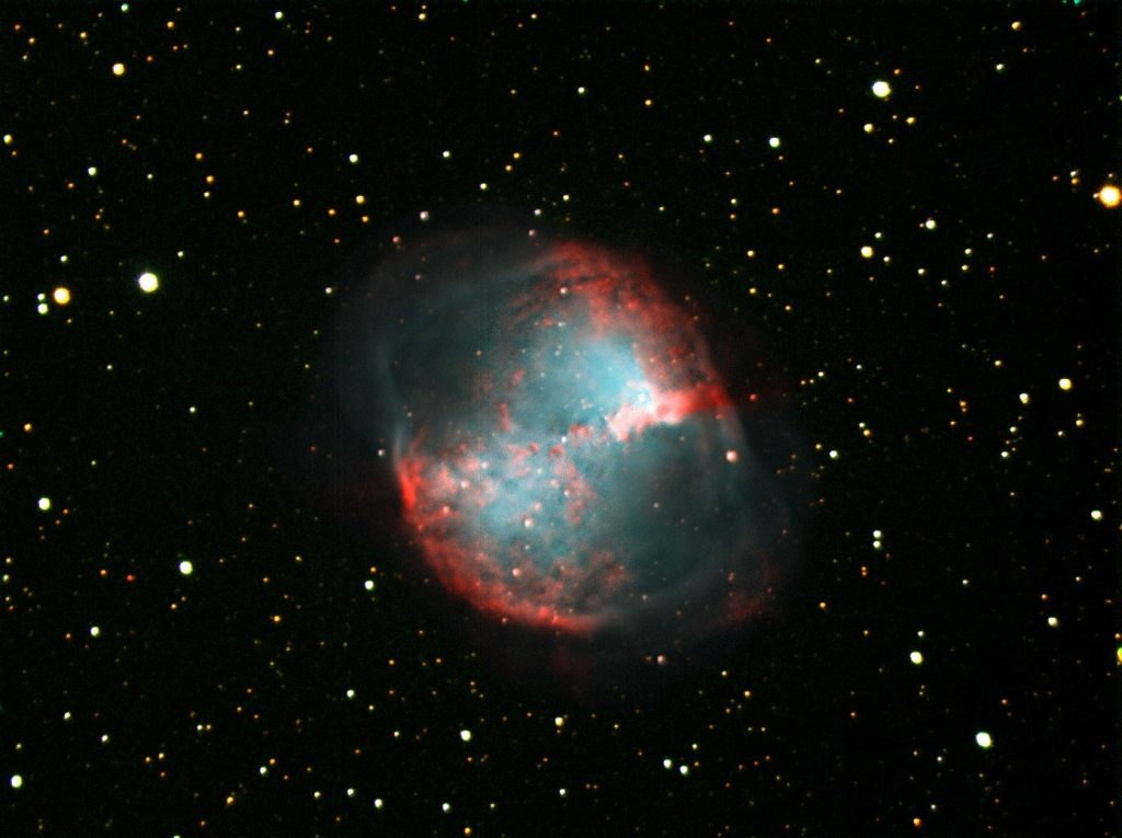 A nebula with a blue-green core and a red outer shell, among the stars